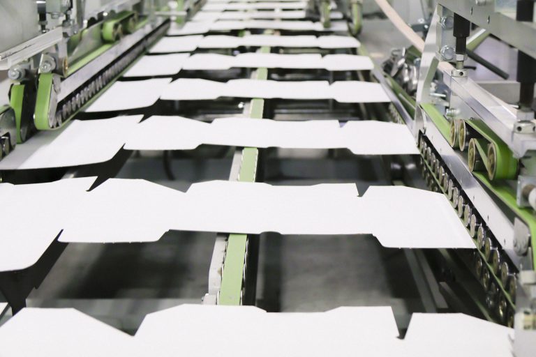 High-speed die-cutting line running carton blanks through a converting press